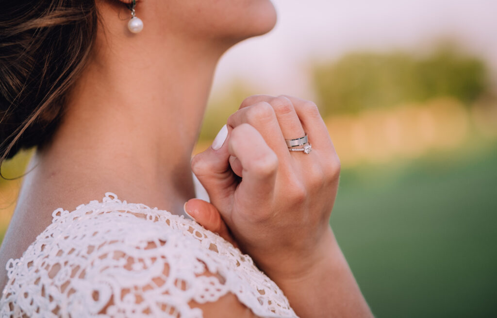 girl white dress with white earrings holding hands near neck