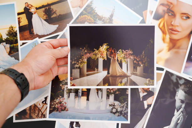 Hand holding a wedding photo over a collage of romantic portraits, capturing memories from a beautifully decorated ceremony.